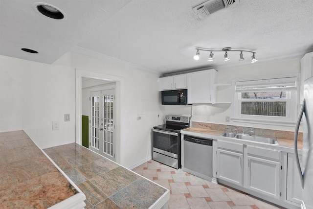 kitchen featuring sink, french doors, white cabinetry, and appliances with stainless steel finishes