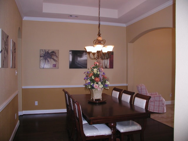 dining area featuring a chandelier, crown molding, and a tray ceiling