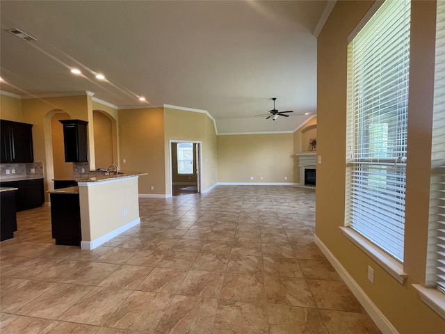 kitchen with ceiling fan, sink, light tile patterned floors, and ornamental molding