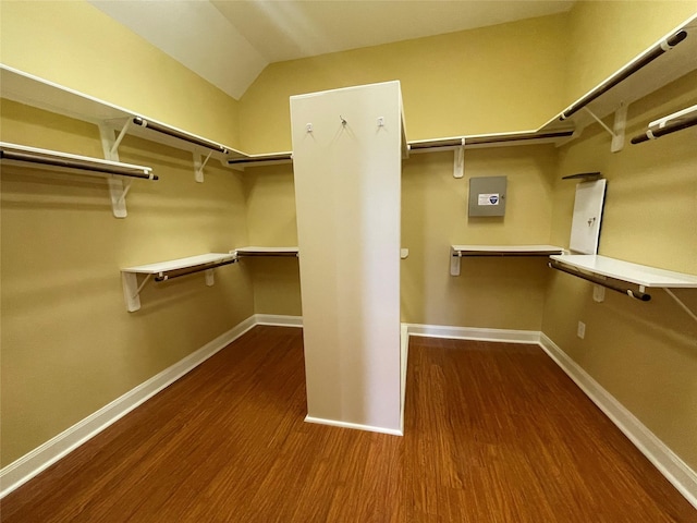 spacious closet with hardwood / wood-style floors and vaulted ceiling