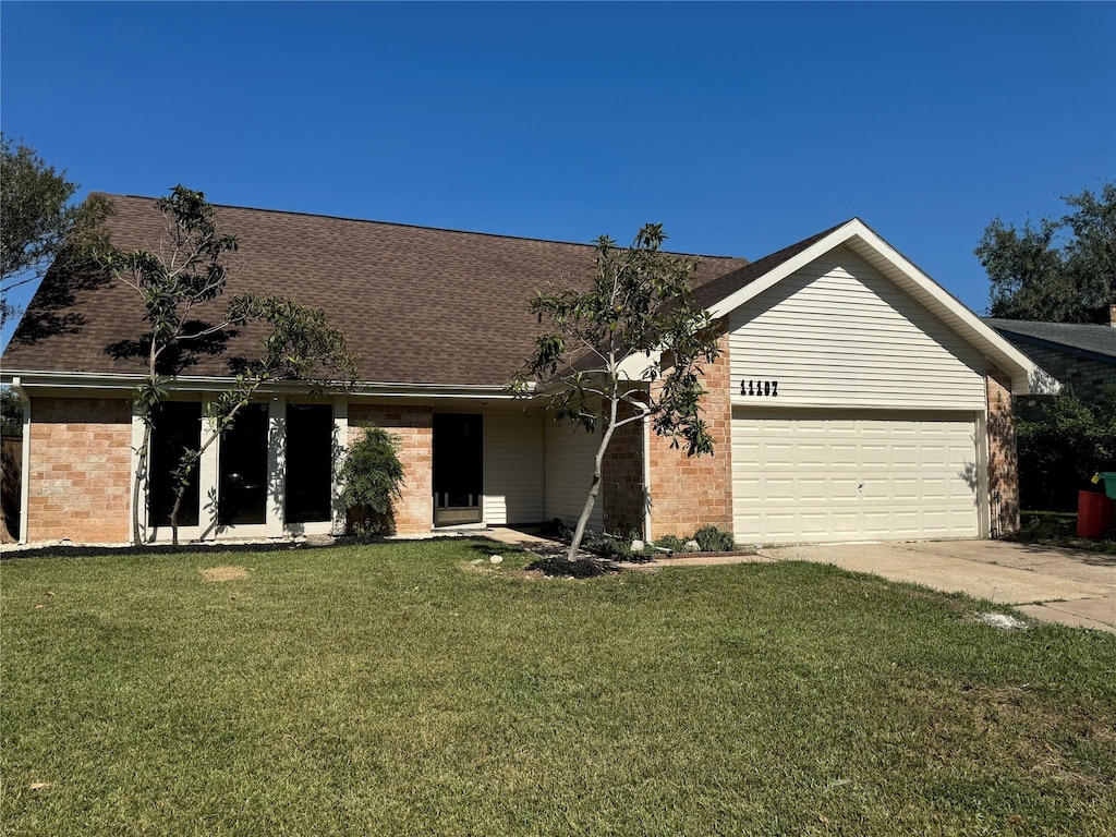 ranch-style house featuring a garage and a front lawn