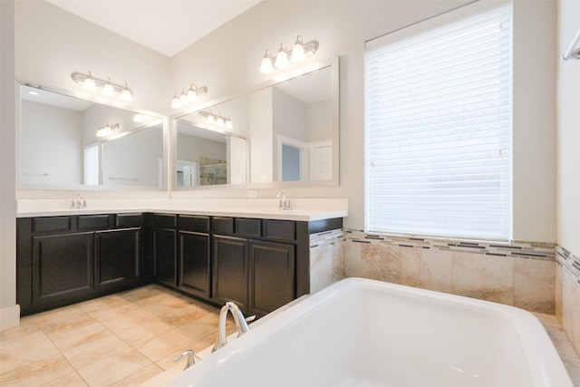 bathroom with a washtub, tile patterned flooring, and vanity