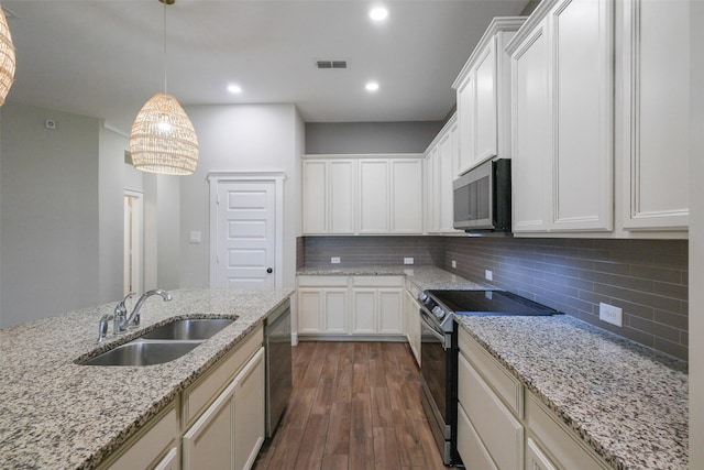 kitchen with sink, light stone countertops, white cabinets, and appliances with stainless steel finishes