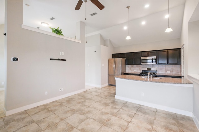 kitchen featuring pendant lighting, appliances with stainless steel finishes, backsplash, light stone countertops, and high vaulted ceiling