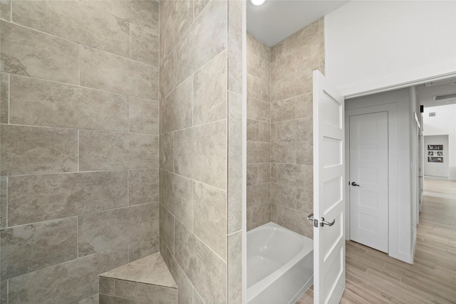 bathroom with wood-type flooring and a bathtub