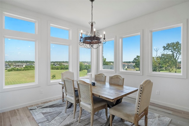 dining area featuring light wood-type flooring and an inviting chandelier