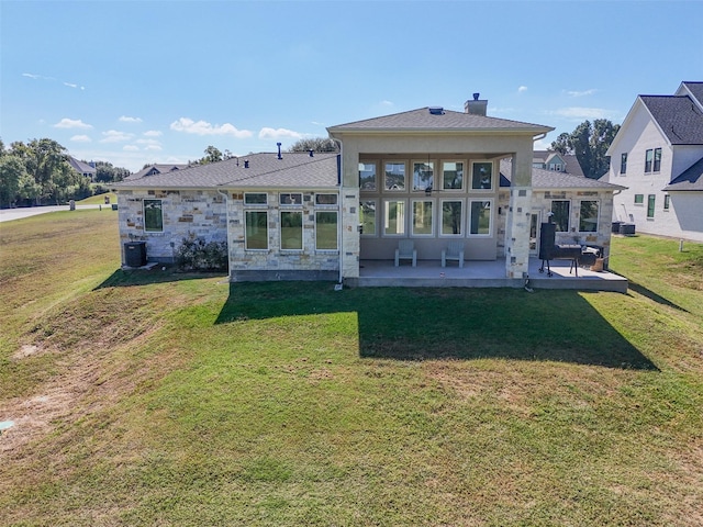 rear view of property featuring cooling unit, a yard, and a patio