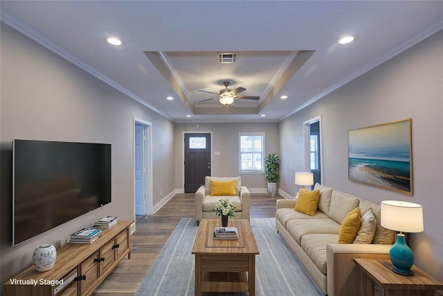 living room featuring crown molding, hardwood / wood-style flooring, ceiling fan, and a raised ceiling