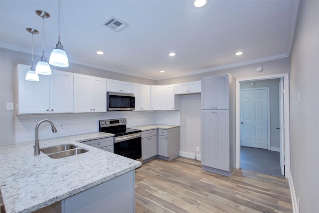 kitchen with kitchen peninsula, hanging light fixtures, appliances with stainless steel finishes, sink, and decorative backsplash