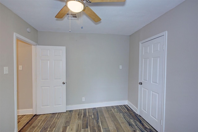 unfurnished bedroom featuring ceiling fan, dark wood-type flooring, and a closet