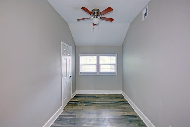 empty room featuring dark wood-type flooring, vaulted ceiling, and ceiling fan