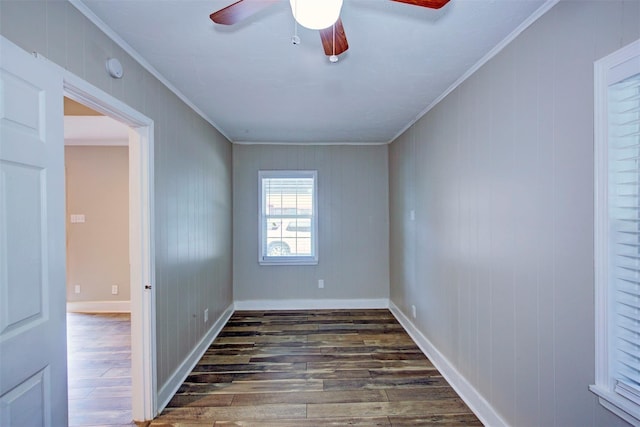 empty room featuring ceiling fan, crown molding, dark hardwood / wood-style floors, and wooden walls