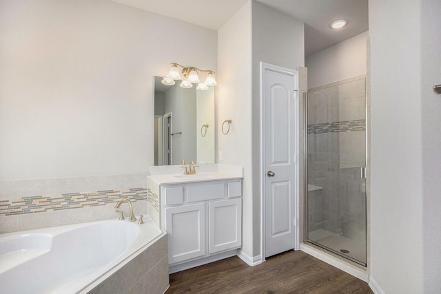 bathroom featuring hardwood / wood-style flooring, vanity, and separate shower and tub