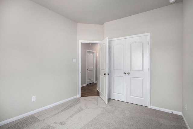 unfurnished bedroom with a closet and light carpet