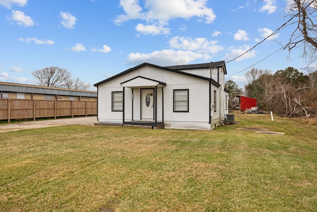 view of front of property with a front yard and central AC unit