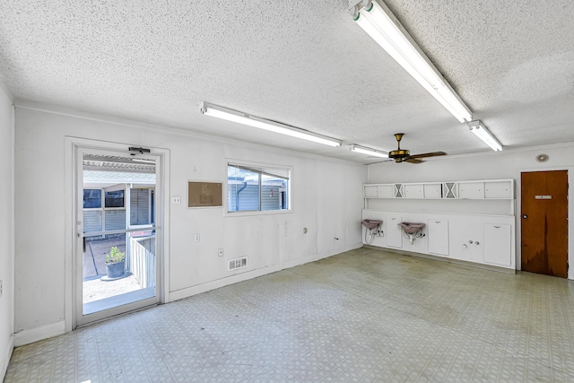 empty room with a textured ceiling and ceiling fan