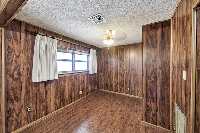 unfurnished room featuring hardwood / wood-style flooring and wood walls