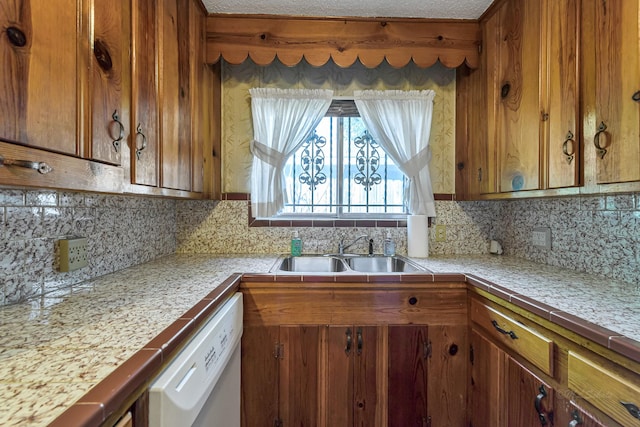 kitchen with sink, backsplash, dishwasher, and tile counters