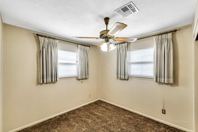 carpeted spare room featuring a textured ceiling and ceiling fan