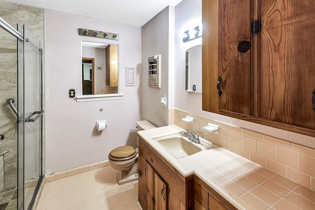 bathroom featuring toilet, a shower with shower door, tasteful backsplash, tile patterned flooring, and vanity