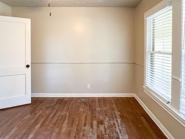 unfurnished room with dark hardwood / wood-style flooring