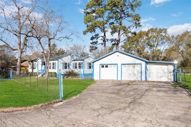 view of front of home with a garage, a front yard, and an outdoor structure