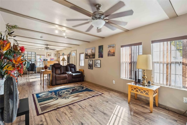 living room featuring light wood-type flooring, ceiling fan, and beam ceiling