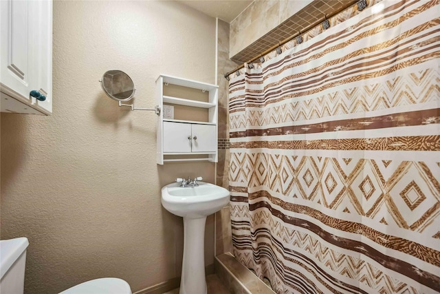 bathroom featuring curtained shower and toilet