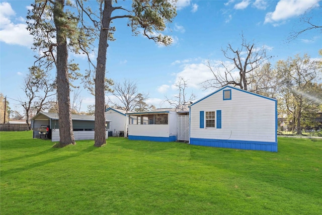 back of house with a yard and a sunroom