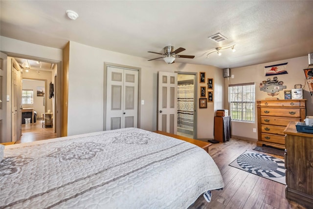 bedroom featuring hardwood / wood-style floors, a textured ceiling, and ceiling fan