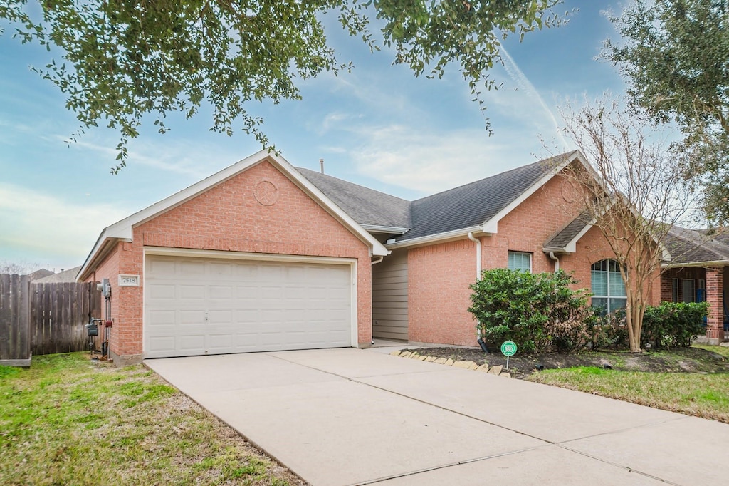 ranch-style house with a garage and a front lawn