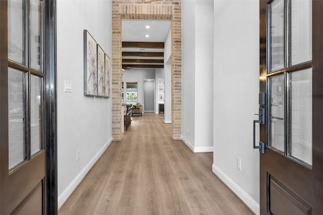 foyer featuring light hardwood / wood-style floors and beam ceiling