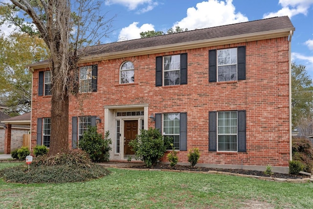 colonial inspired home featuring a front lawn