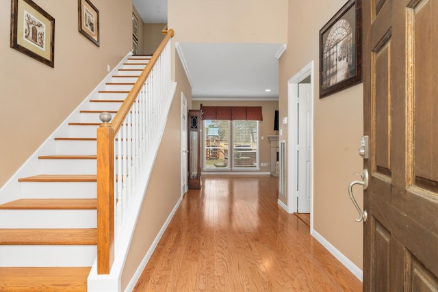 entryway featuring ornamental molding and light wood-type flooring