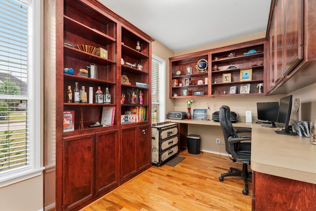 office area with built in desk and light wood-type flooring