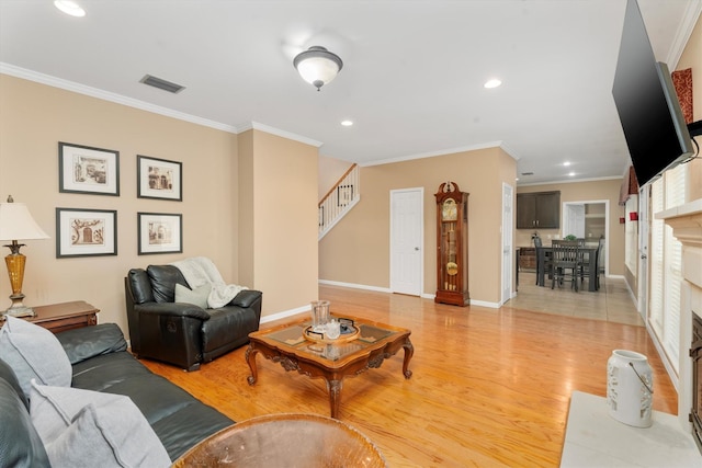 living room featuring crown molding and light hardwood / wood-style flooring