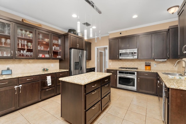 kitchen featuring sink, appliances with stainless steel finishes, dark brown cabinetry, a kitchen island, and decorative backsplash