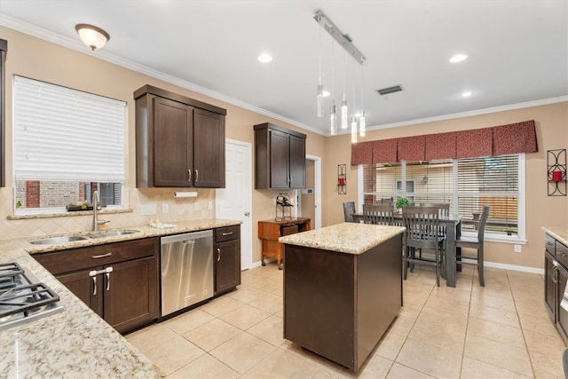 kitchen featuring sink, hanging light fixtures, stainless steel appliances, a center island, and ornamental molding