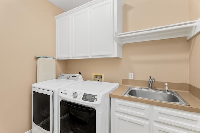 clothes washing area with cabinets, washing machine and clothes dryer, and sink