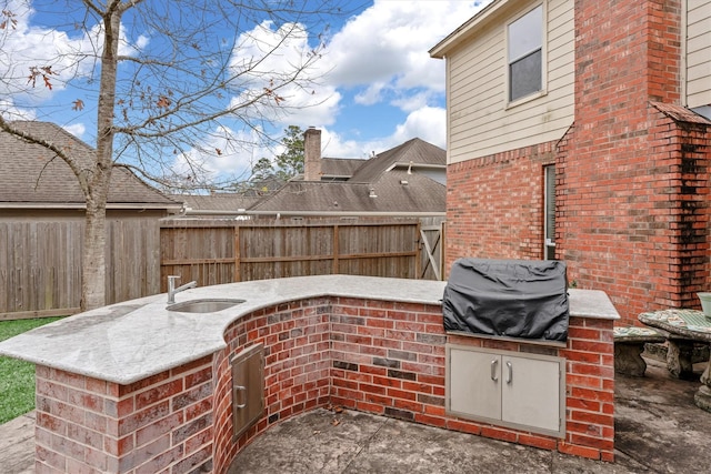 view of patio / terrace featuring grilling area, an outdoor bar, and exterior kitchen