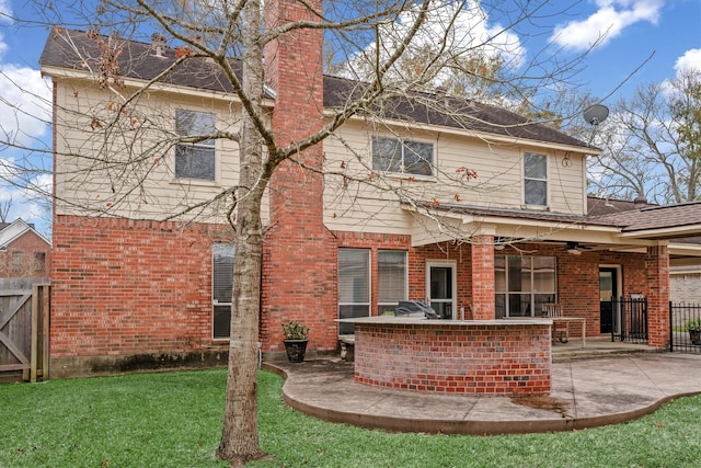 back of property with a patio, exterior bar, ceiling fan, and a lawn