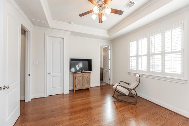 sitting room featuring ceiling fan, ornamental molding, dark hardwood / wood-style floors, and a tray ceiling