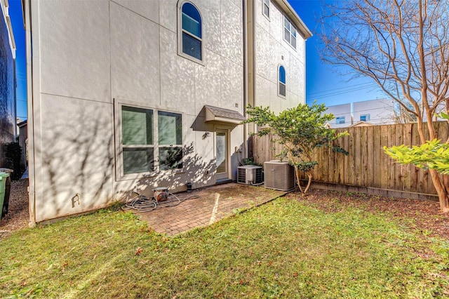 rear view of house with a patio area, a lawn, and cooling unit