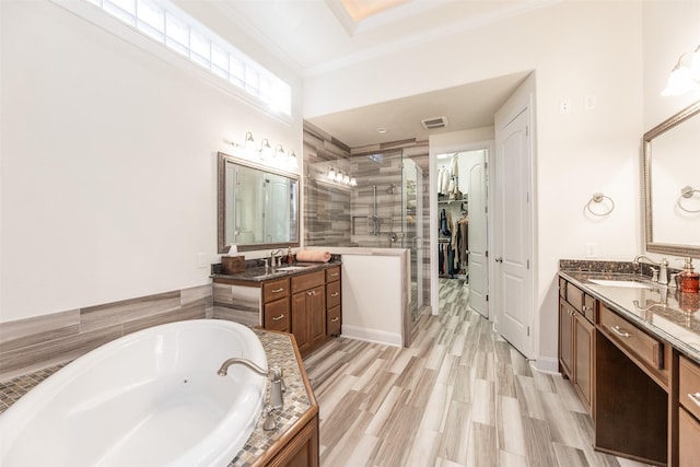 bathroom featuring ornamental molding, independent shower and bath, hardwood / wood-style flooring, and vanity