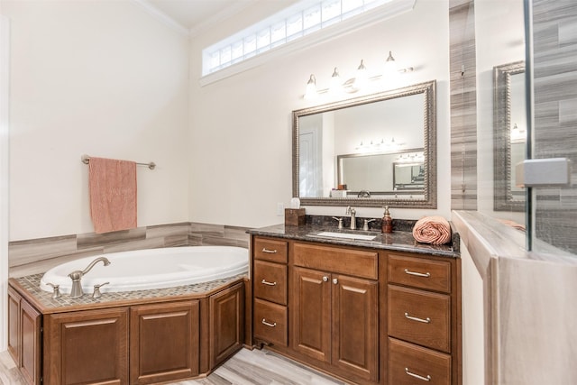 bathroom with vanity, ornamental molding, hardwood / wood-style floors, and a bathing tub