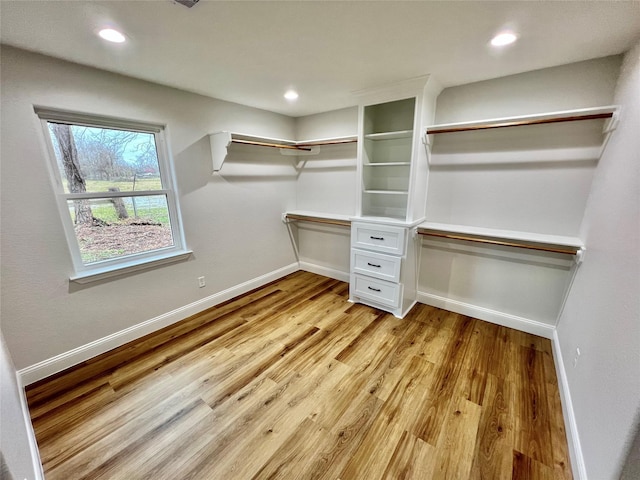 walk in closet with light hardwood / wood-style floors