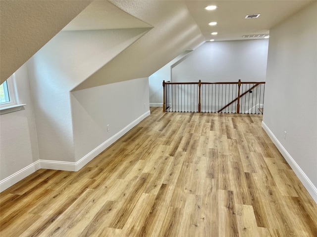 bonus room featuring light hardwood / wood-style flooring and vaulted ceiling