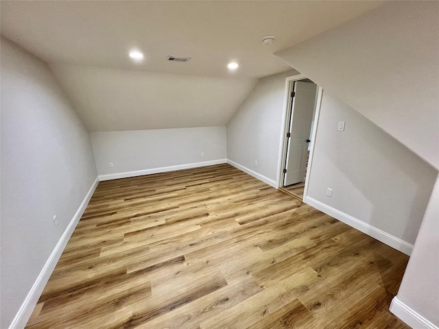 additional living space featuring light hardwood / wood-style flooring and lofted ceiling