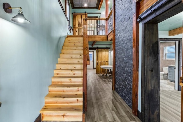 stairway with a high ceiling and hardwood / wood-style floors