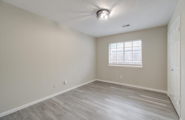 unfurnished bedroom with a closet, light hardwood / wood-style flooring, and a textured ceiling